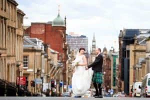 a wedding couple cross the road on their wedding day in glasgow