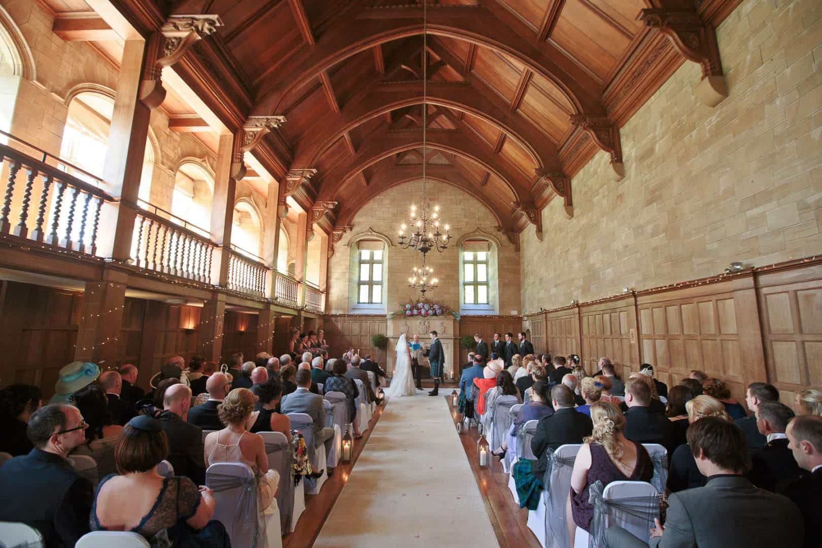 a wedding couple take their vows in achnagairn great hall