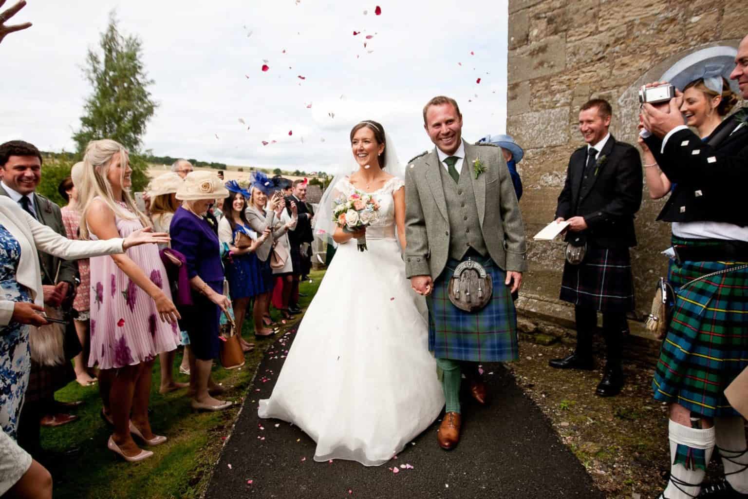 fife wedding photographer a couple walk through confetti on their wedding day