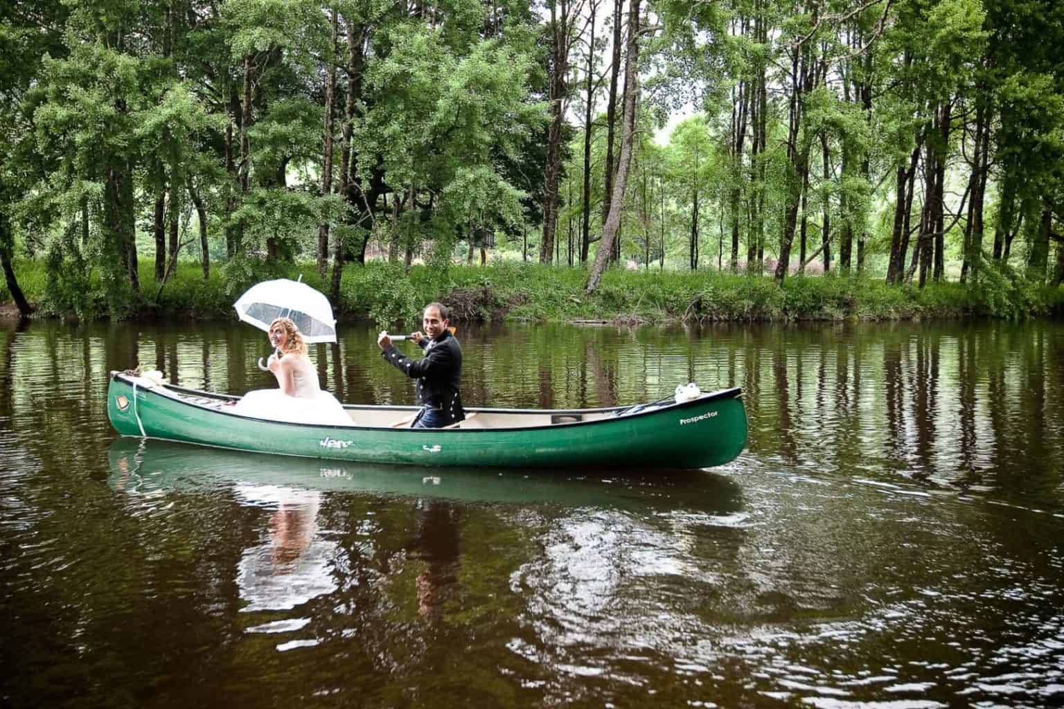 quirky wedding photography a wedding couple take a kayak down the river on their wedding day
