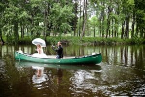 a wedding couple take a kayak down the river on their wedding day