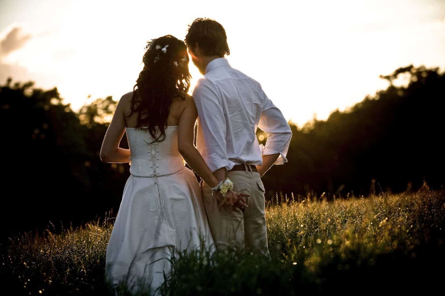 scottish-wedding-photography a couple stand in a field during sunset on their wedding day
