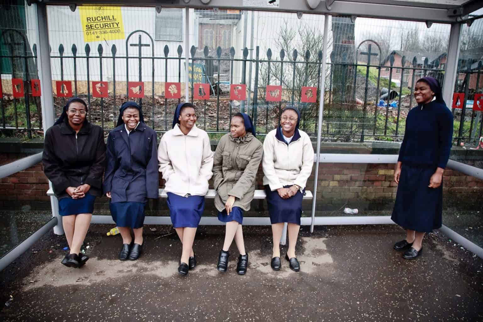 a-glasgow-story-editorial-portrait-of-nuns 6 nuns laugh at the photographer at a bus stop in glasgow