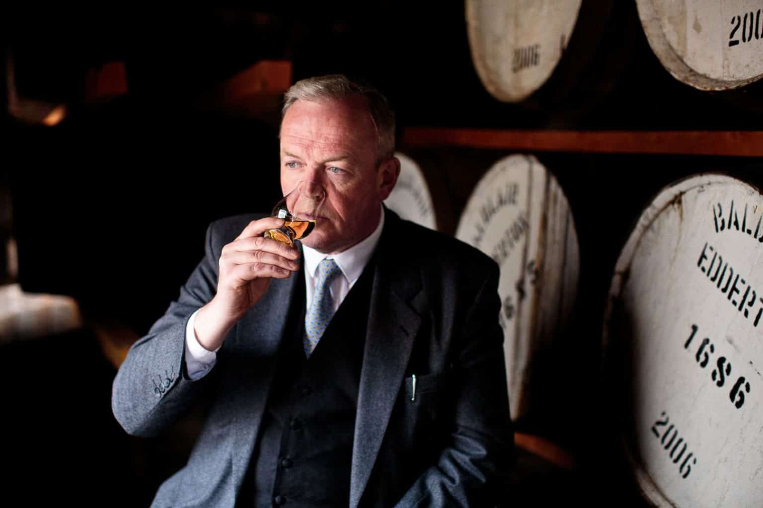 balblair-whisky-distillery-portrait john macdonald of balblair distillery noses a glass of whisky in a warehouse