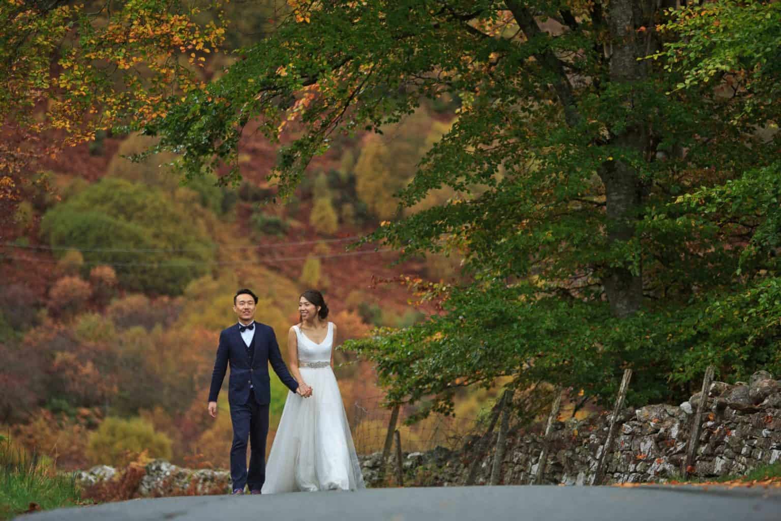 elope-to-the-scottish-highlands a bride and groom walk up an autumnal path in scotland