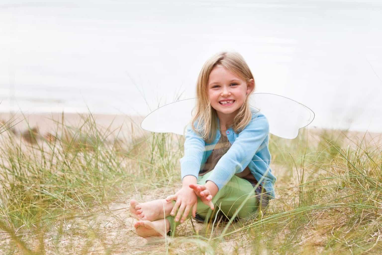 moray-beach-photographer a young girl looks at the camera on a beach in morayshire
