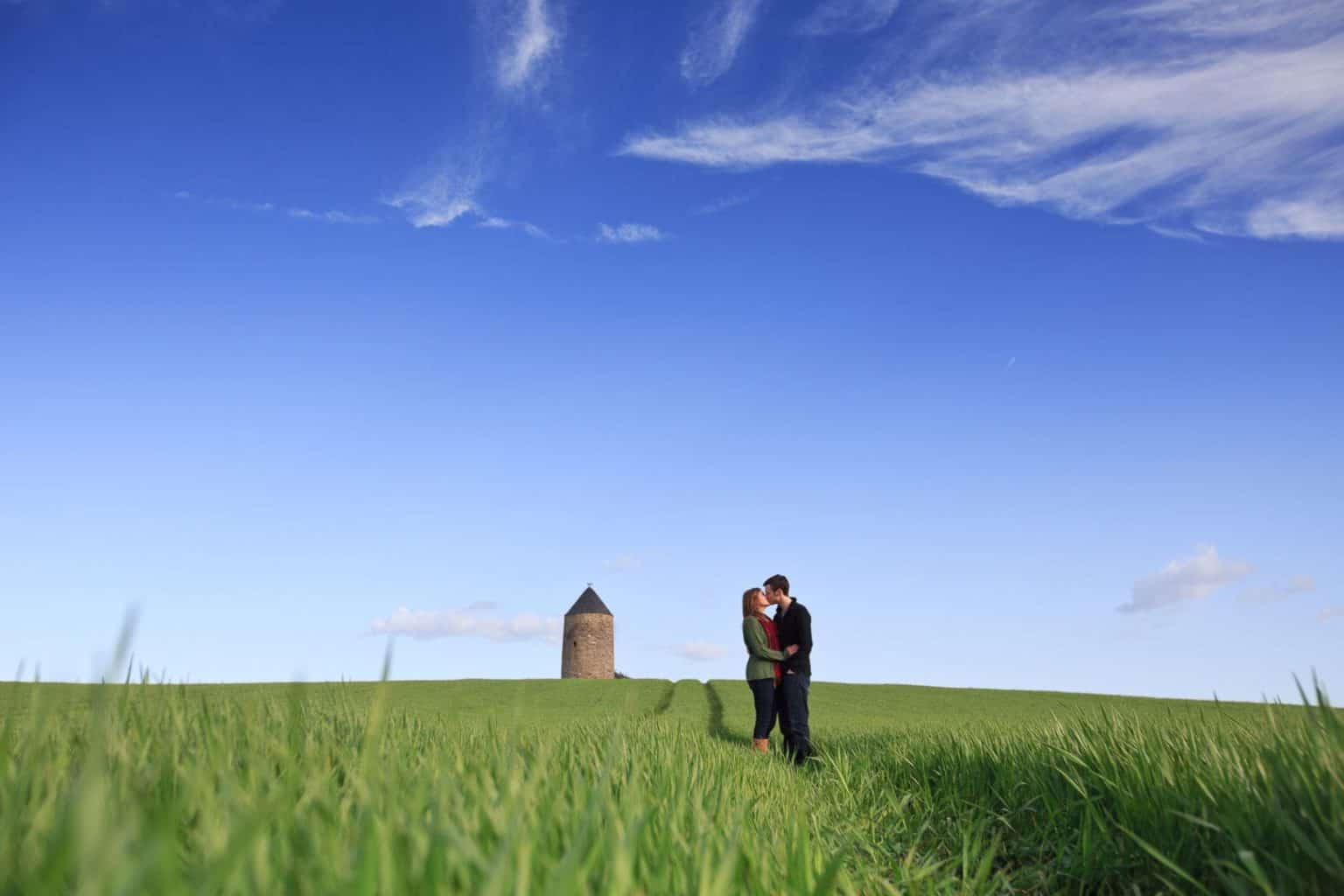 pre-wedding-photography a scottish couple pose in a field during their engagement photography session