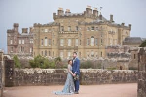a bride and groom who chose to get married in a scottish castle stand outside of culzean castle after thier wedding ceremony